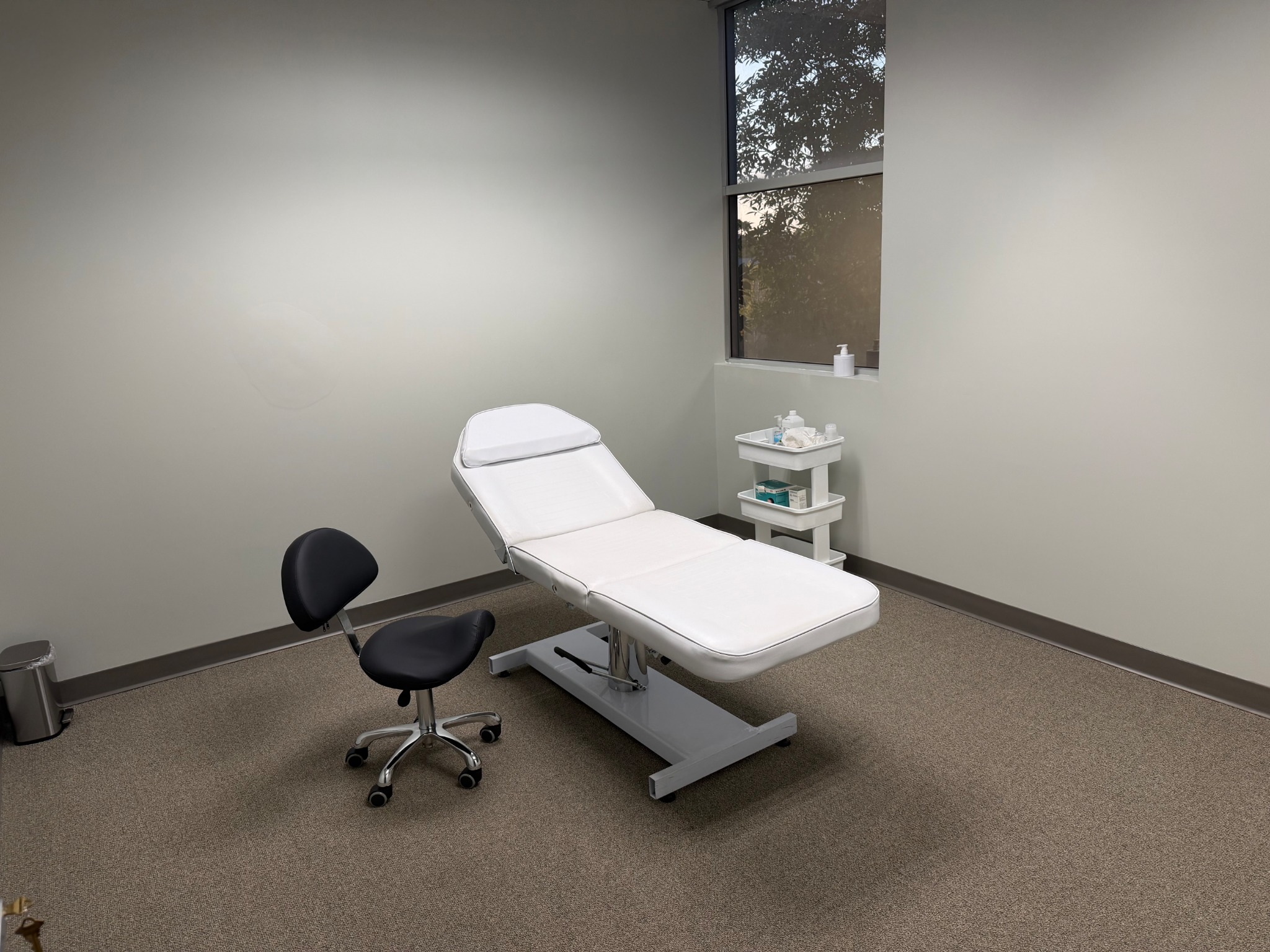 Treatment room with a white adjustable treatment bed